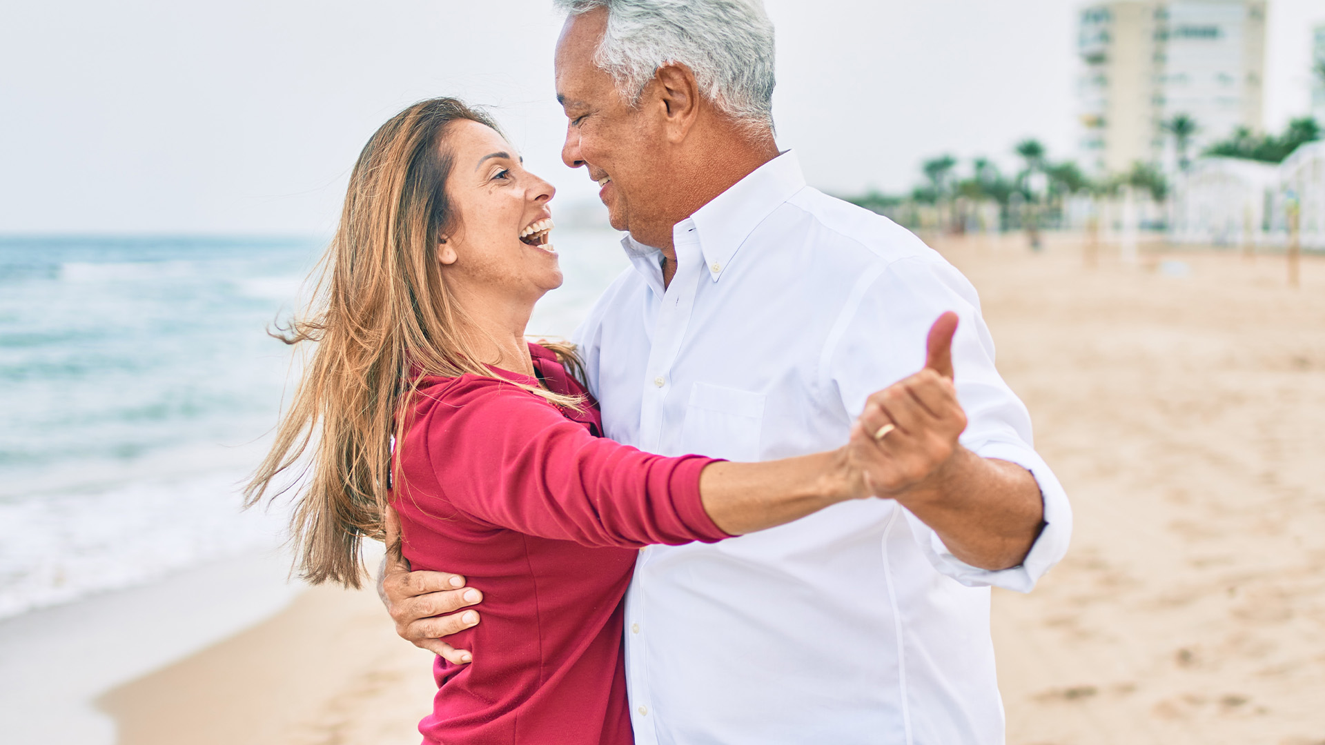 Senior couple smiling and dancing close together with hands held