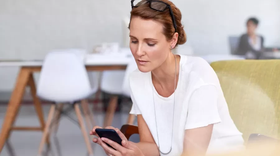 Middle aged woman sitting and looking at cell phone