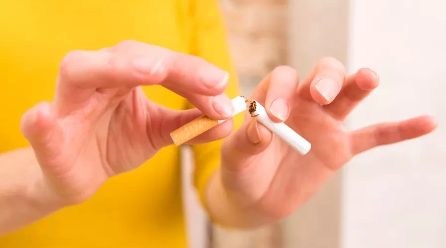 Person breaking cigarette in half with hands