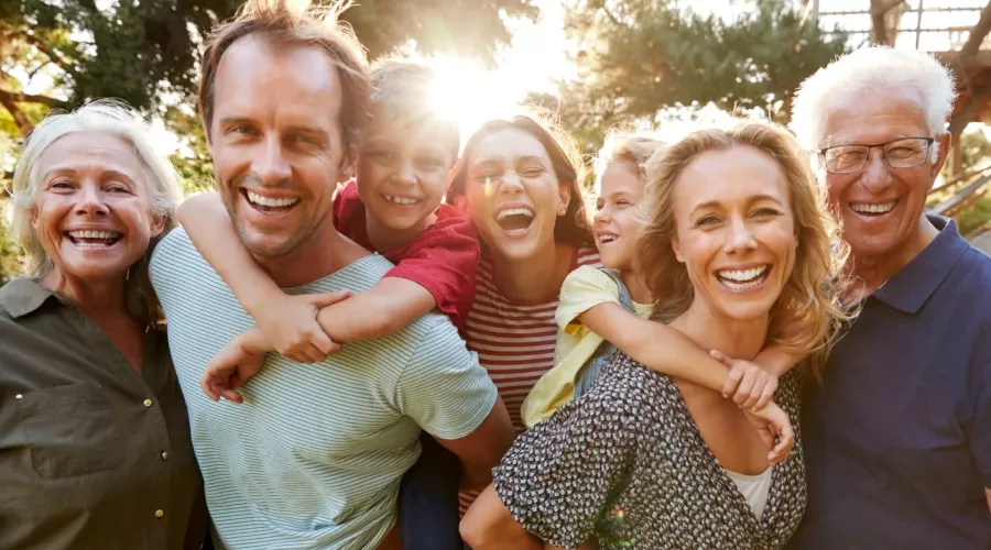 Middle-Aged Mother and Father with kids and grandparents laughing and smiling outside
