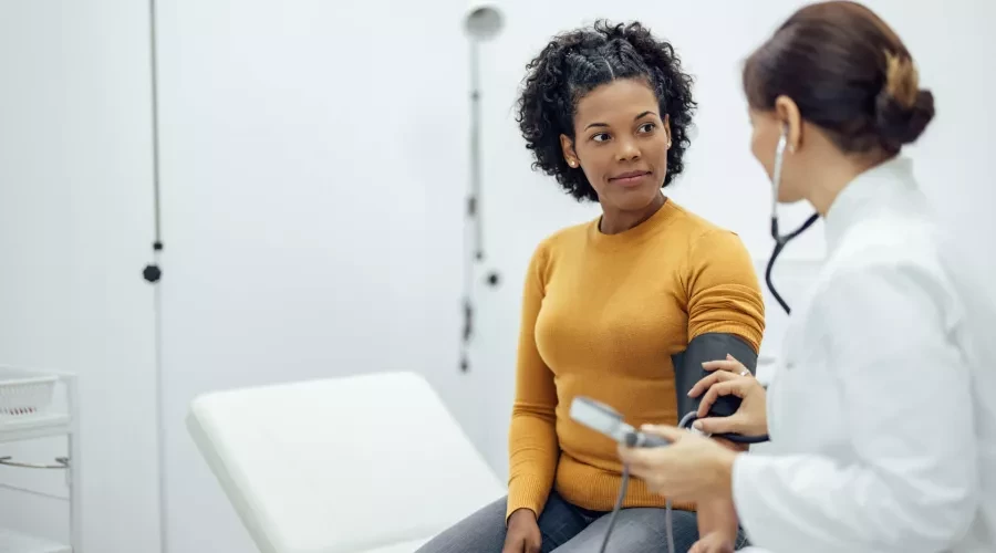 Woman having blood pressure test wit doctor in doctors office