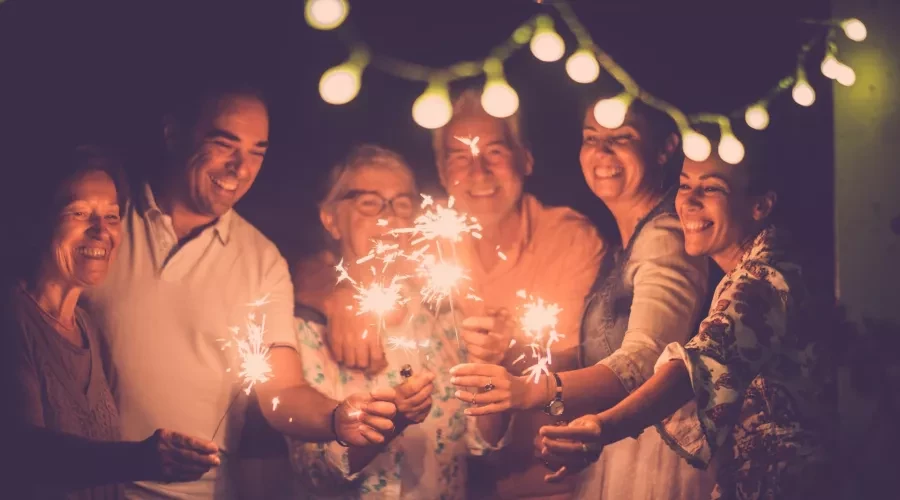 Friends celebrating new years, smiling and holding sparklers