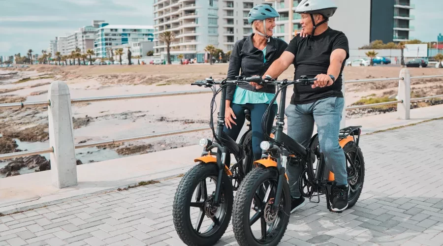 a couple on e-bikes outside on beach trail