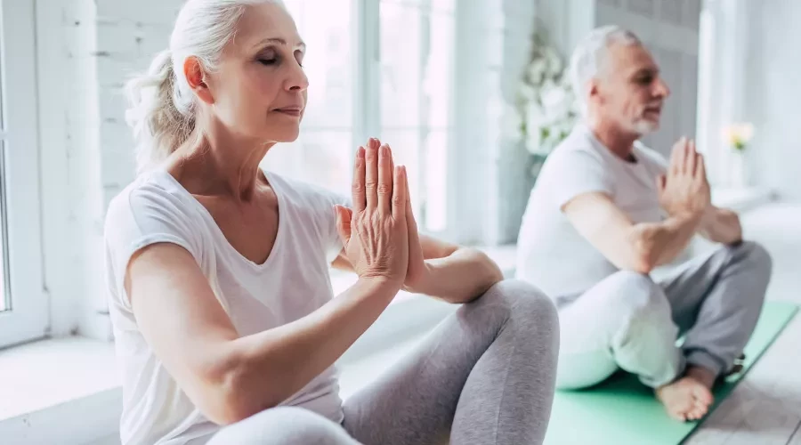 Senior Couple In Seated Prayer Yoga Pose