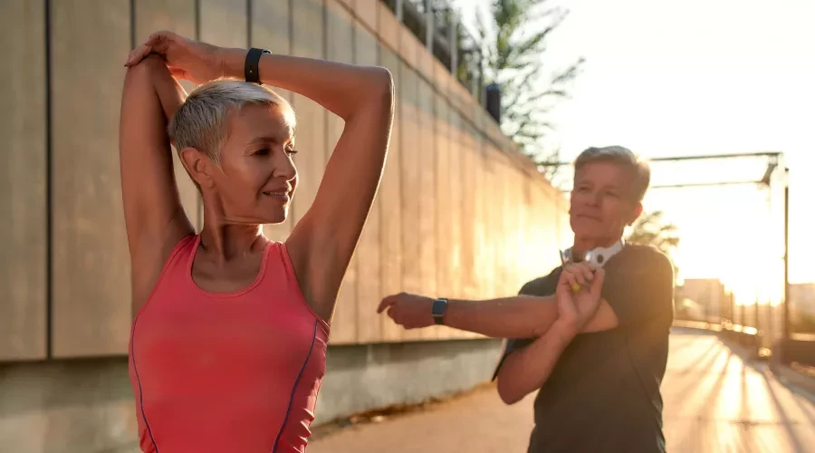 A man and a woman stretching before exercising.