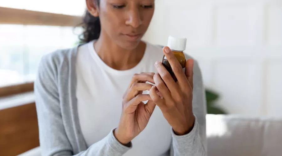 Woman Looking at Bottle Details