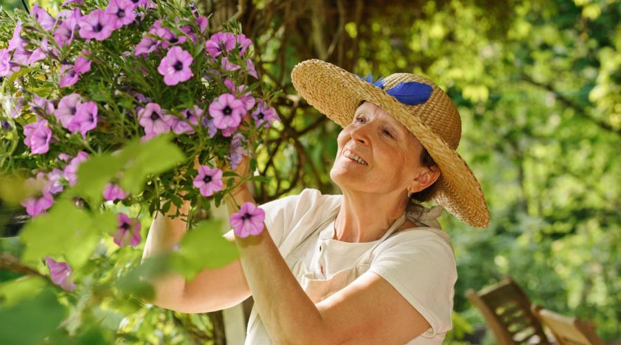 A woman trims flowers in her garden