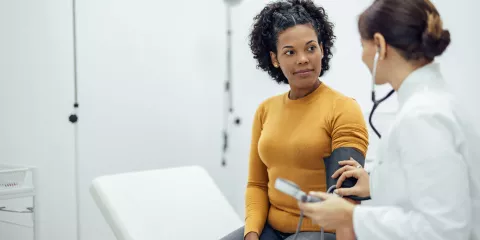 Woman having blood pressure test wit doctor in doctors office