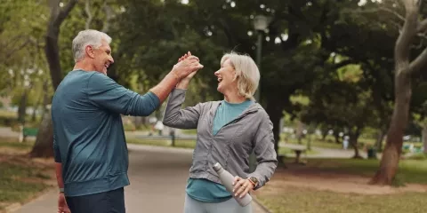 A middle aged man and woman high fiving 