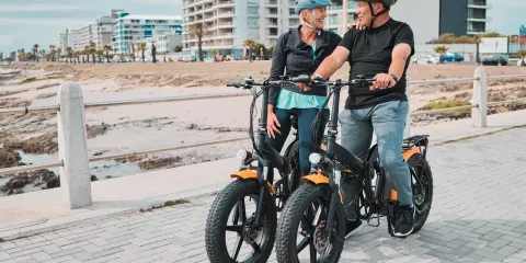 a couple on e-bikes outside on beach trail 