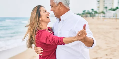 Senior couple smiling and dancing close together with hands held