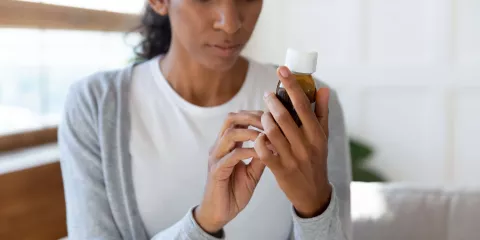 Woman Looking at Bottle Details