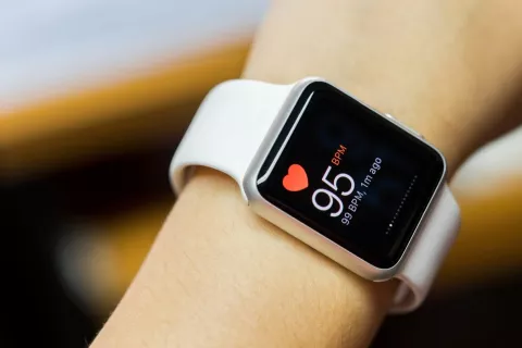 Womans arm with fitness watch showing heart rate 