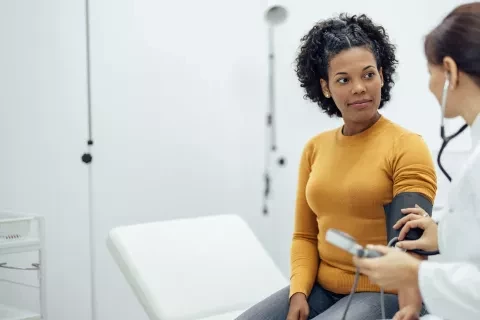 Woman having blood pressure test wit doctor in doctors office