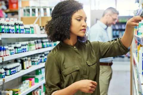Woman in pharmacy, shopping for supplements 