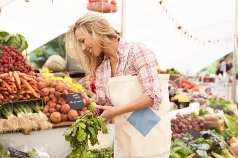 Woman smiling and shopping at Farmers Market