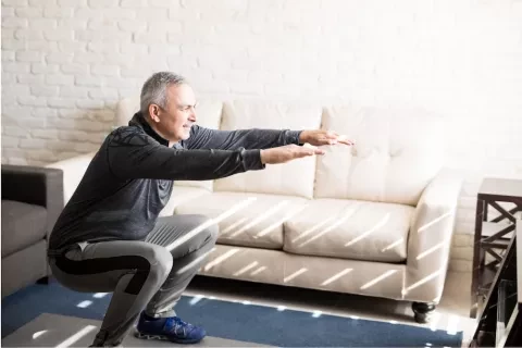 man stretching in living room