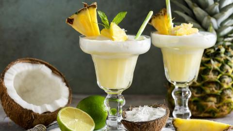 tropic tranquility mocktail on table with coconut, lime and pineapple